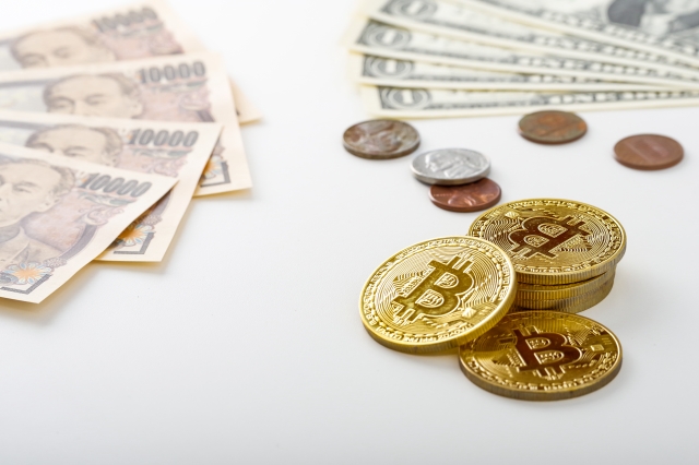 テーブルに並んだ仮想通貨のコインとお札