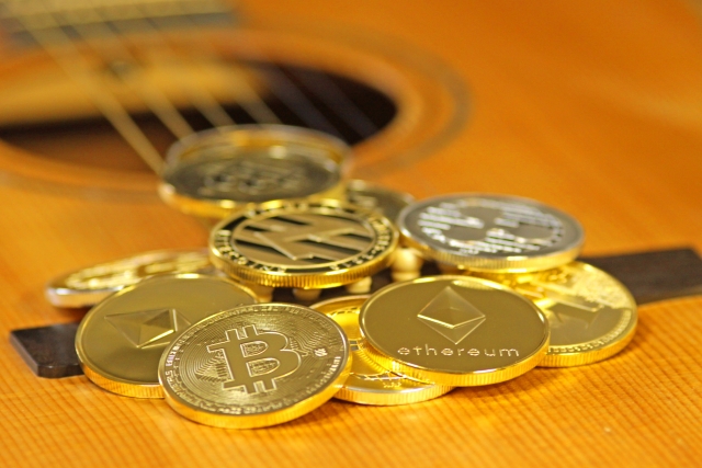 ギターの上に乱雑に置かれた複数のコイン