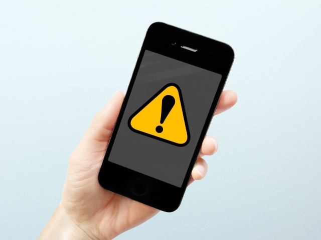 スマートフォン画面への警告マーク表示写真