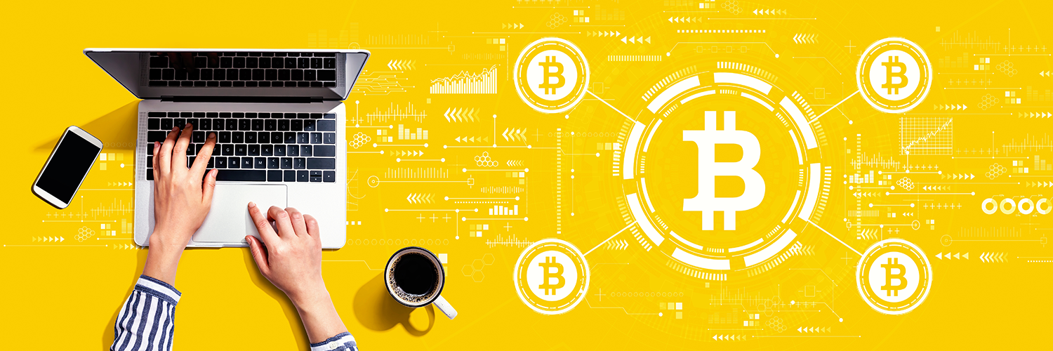 ノートブックパソコンとビットコインのロゴイメージ