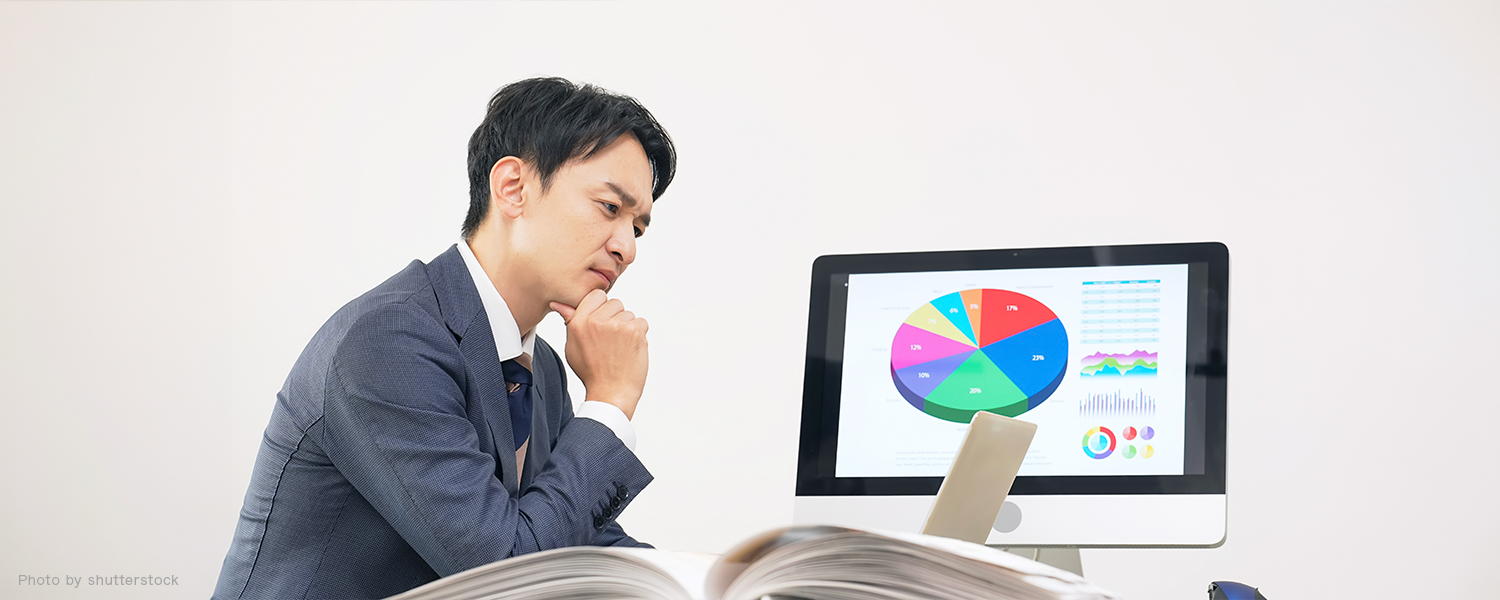 パソコン見て検討している男性