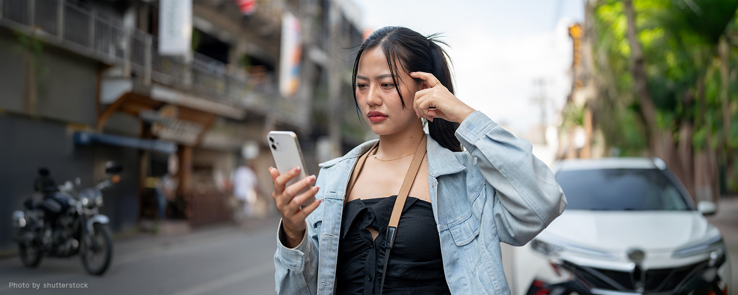 スマホ見ながら考え中の女性
