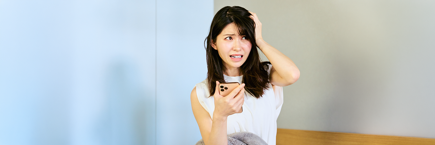 スマホを持つ困った女性